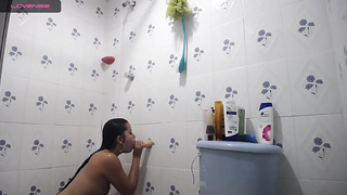 German black-haired is having a douche in front of the camera and even stroking a bit