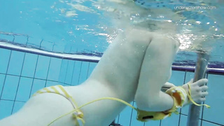 Uber-Cute dark-haired teenie loves swimming and diving nude in the pool, in the middle of the day