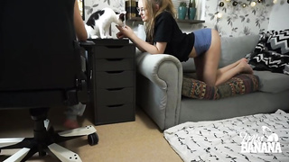 Nerdy woman with glasses is gargling her roomy's pipe while getting down on all fours in front of him