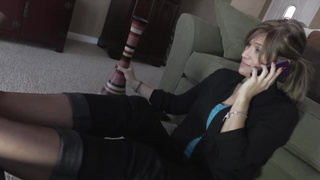 Mature doll is demonstrating her soles while dressed in nylons and conversing on the smartphone with her paramour