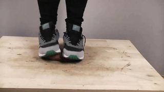 Accomplished nymph is dressed in sports boots while providing a feetjob to a boy from the surroundings