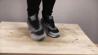 Accomplished nymph is dressed in sports boots while providing a feetjob to a boy from the surroundings