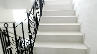 Slender female with diminutive udders is dressed in high high-heeled shoes while jacking on the staircase during the day