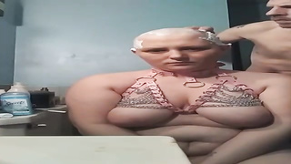 Lush female with monstrous globes is getting her head shaven in front of the camera