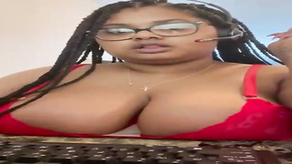 Big-Titted Ebony gal in softcore, crimson underwear is posing and taunting in front of the camera