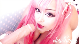 Pinkish haired doll is fellating a large, faux rod in front of the camera, just for joy