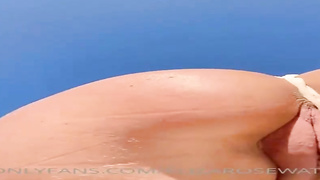 Beach stunner in a rope swimsuit poses in a close-up for the camera showcasing off her clean-shaved twat