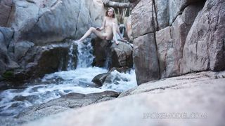 Kinky chick stretching at kinky waterfall