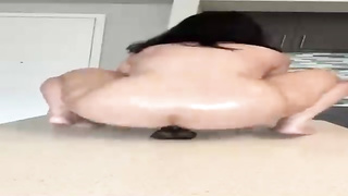 Super-Naughty woman with a hefty, rigid arse is juggling up and down while railing a black fake penis
