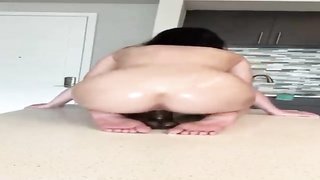 Super-Naughty woman with a hefty, rigid arse is juggling up and down while railing a black fake penis