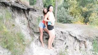 Bare teenies are pawing each other in the nature, in the middle of the day