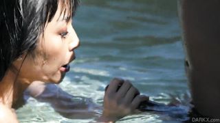 Chinese honey seducing a dark-hued boy in the pool