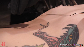 Tattooed slave in doggy type position whipped