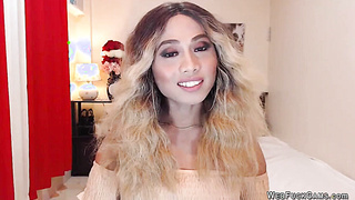 Asain blonde TS wanks cock in chair in front of webcam