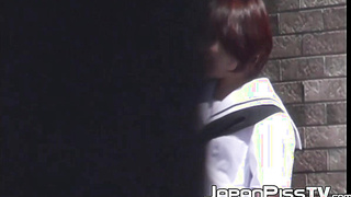 Ginger-haired Asian with brief hair is pissing on the streets