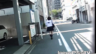 Ginger-haired Asian with brief hair is pissing on the streets