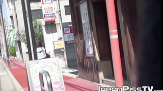 Ginger-haired Asian with brief hair is pissing on the streets