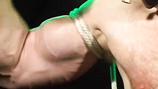 Bigg Pette has his arms trussed with leather and his nutsack tied down to his toes