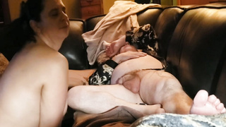 Mature dark haired housewife is blowing her paramour's spear while he is calming on the couch