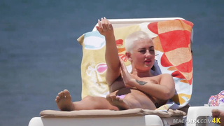 Goth dame with massive bra-stuffers on bra-less beach