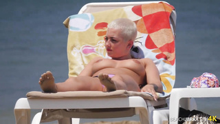 Goth dame with massive bra-stuffers on bra-less beach