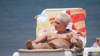 Goth dame with massive bra-stuffers on bra-less beach