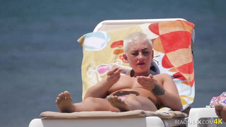 Goth dame with massive bra-stuffers on bra-less beach