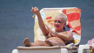 Goth dame with massive bra-stuffers on bra-less beach