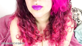 Rosy haired stunner with pierced lips is smoking a ciggy in front of the camera