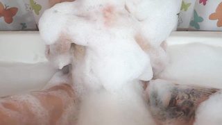 Tatted damsel is having a bathtub and impatiently kneading her labia, to make herself jism