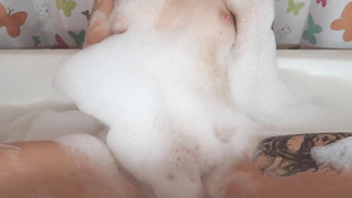 Tatted damsel is having a bathtub and impatiently kneading her labia, to make herself jism