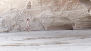 Slender teenager black-haired is posing naked near the rocks and opening up up broad to demonstrate her vag