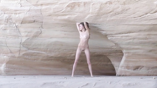 Slender teenager black-haired is posing naked near the rocks and opening up up broad to demonstrate her vag