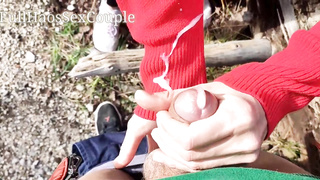 Pretty female in crimson is massaging her beau's fuck-stick in the nature, to make him jizz