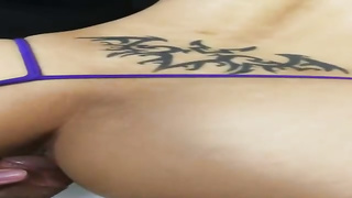 Spunky honey with a tat on her lower back is getting screwed in front of the camera